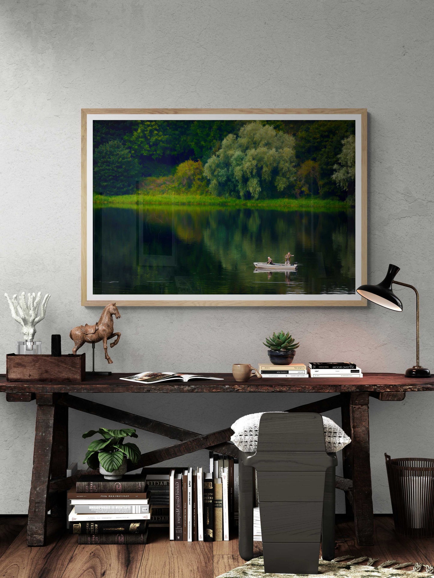 Fishermen on Linlithgow Loch – A Scene of Light, Gesture, and Color framed art print above rustic desk. Tranquil Scottish lake with boat and lush trees.