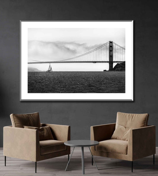 Black and white photo of Golden Gate Bridge with sailboat on the wall of a reception area.