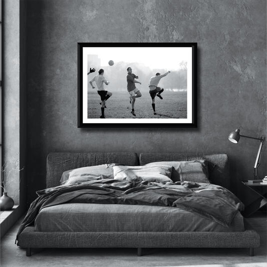 Black and white street photography print of three men playing football in Hyde Park, London on a stylish grey bedroom wall