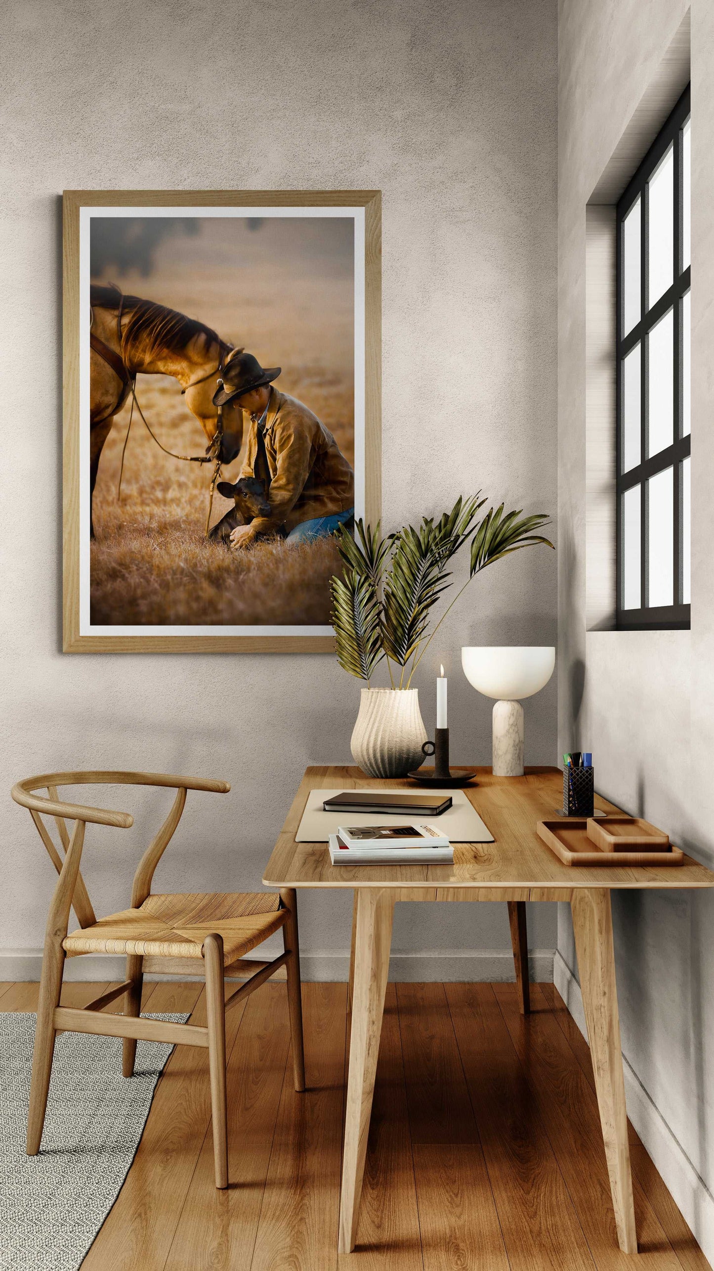Framed cowboy and calf reunion print in a serene reading nook, combining rustic elegance with authentic Texas ranch culture for interior styling.