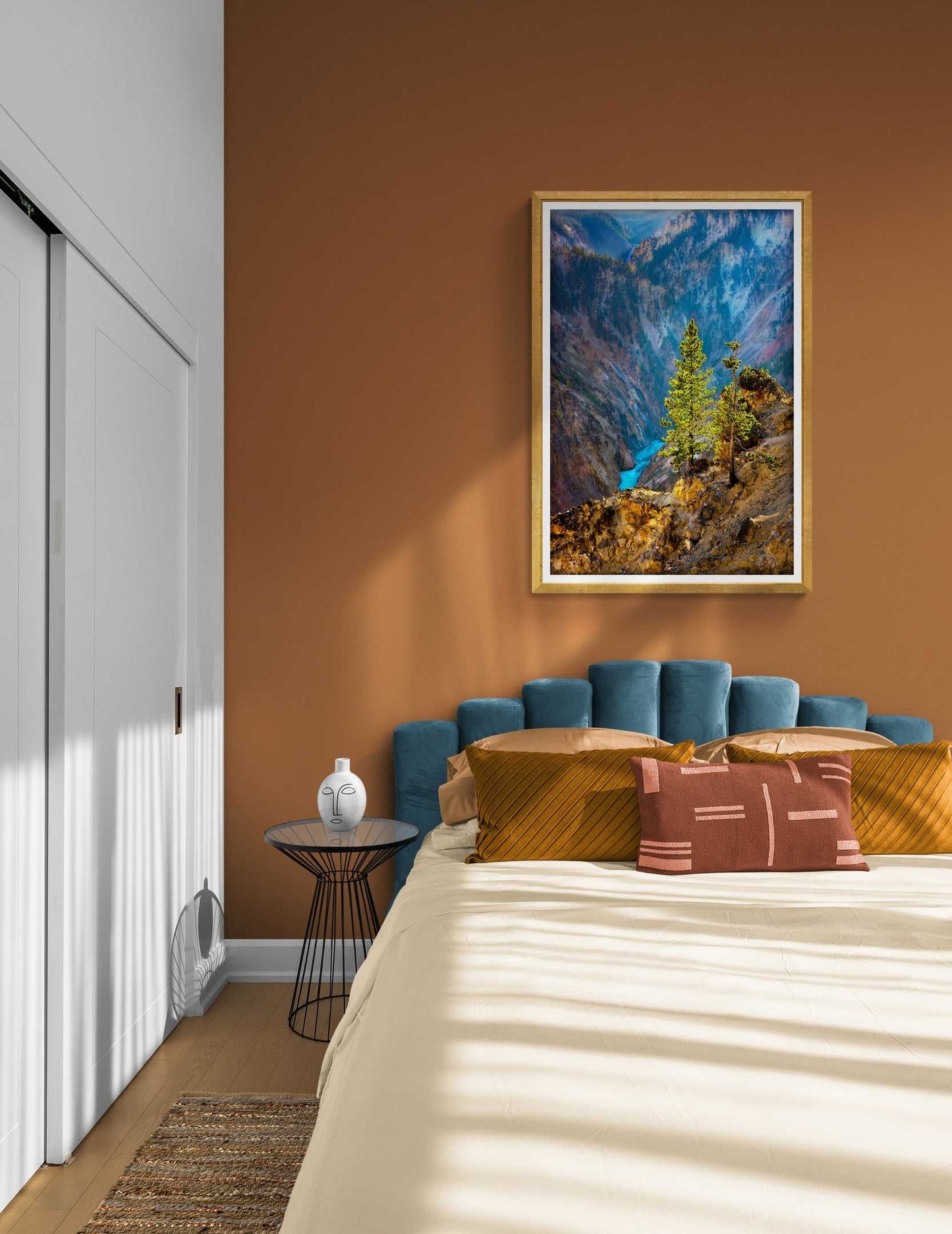 Fine art print of sunlit lone tree over Yellowstone River enhances a cozy bedroom with warm tones. Western landscape wall art for serene interiors.