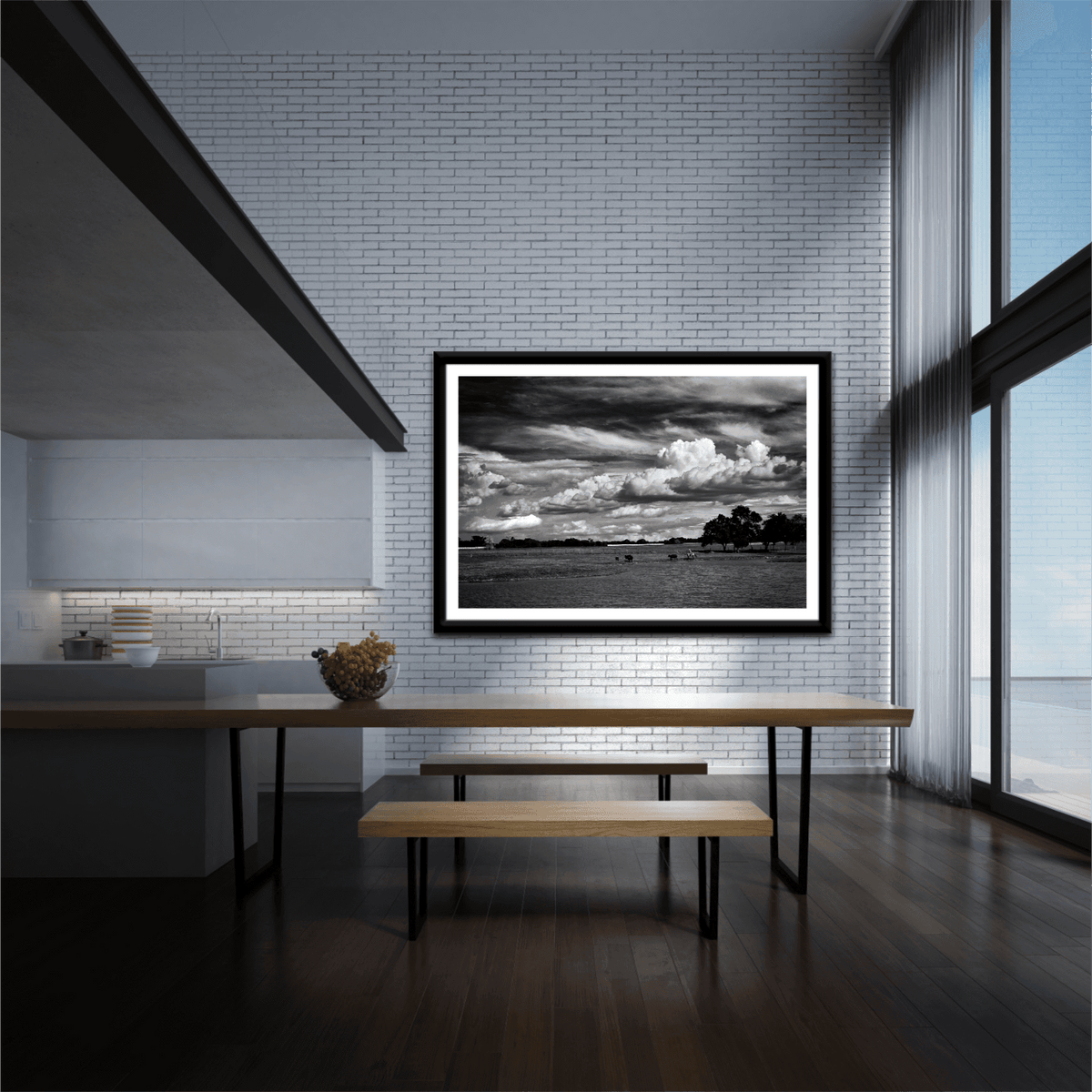 Black and white cowboy herding cattle print 'Under a Texas Sky' displayed in a modern dining area with tall windows and minimalist decor.