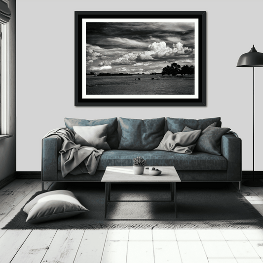 Framed black and white cowboy wall art titled 'Under a Texas Sky' displayed above a blue sofa in a modern living room.