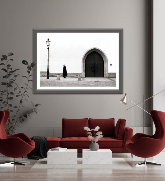 Zurich Series #2 – The Woman and the Church, Black and White Fine Art Print by Michael Hart displayed above a red sofa in a modern living room, enhancing minimalist decor.