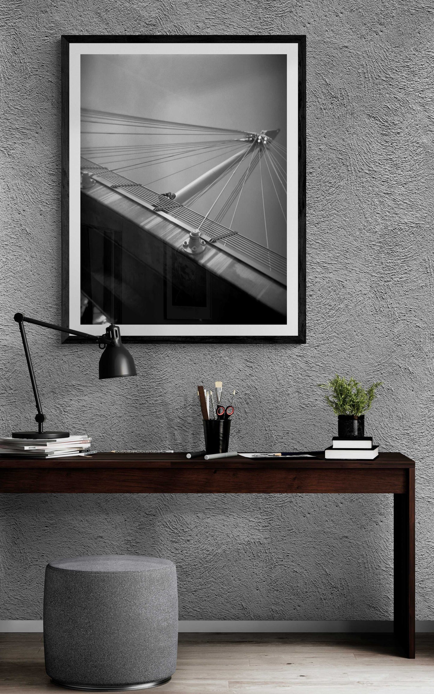 A framed black and white Holga camera image of the Golden Jubilee Bridge in London, England iover a credenza in modern room setting.
