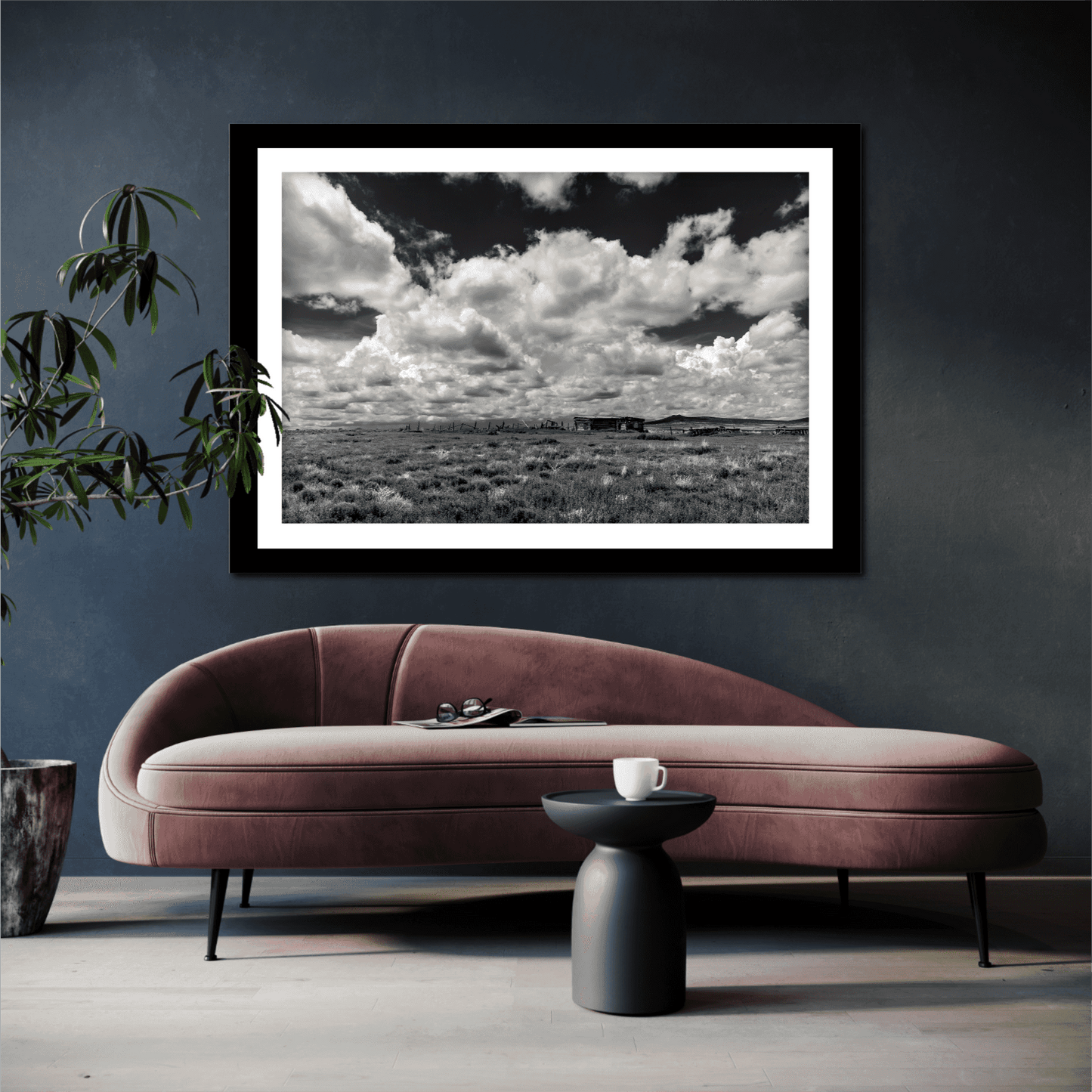 Abandoned New Mexico – Limited Edition Black and White Fine Art Photograph displayed above a modern velvet sofa. Dramatic clouds and ranch ruins evoke solitude.