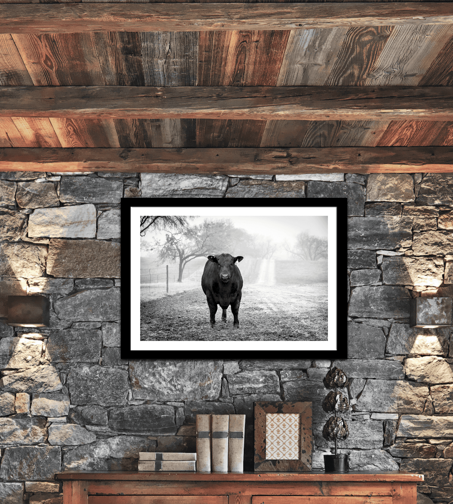 Framed photographic print of a Black Angus bull stands in morning fog on a rustic ranch house stone wall.