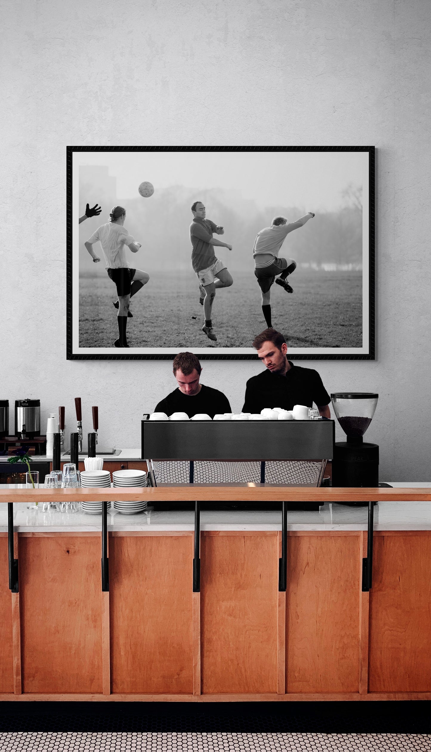 Black and white street photography print of three men playing football in Hyde Park, London