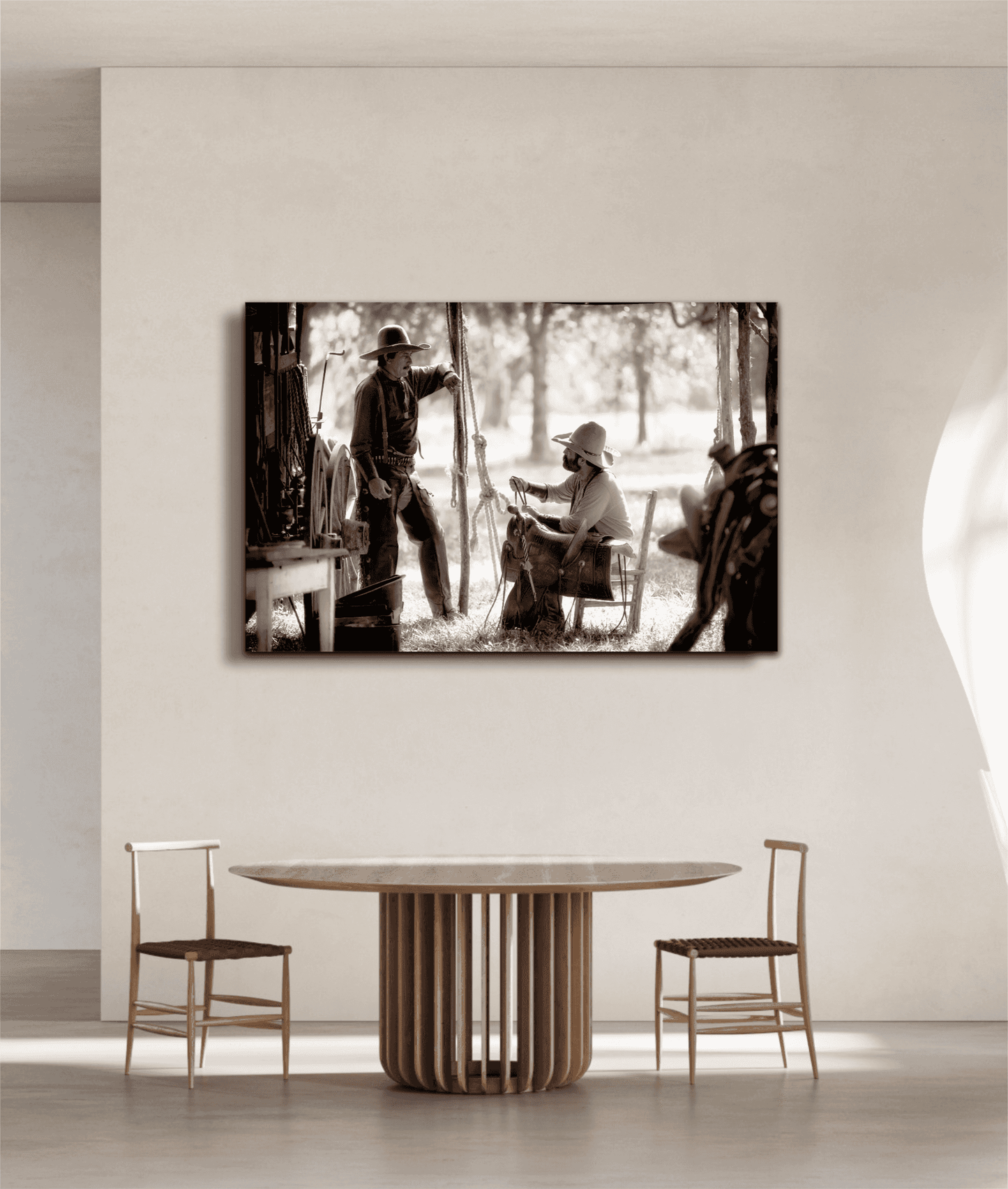 Western fine art print 'Camp Talk: A Chuckwagon Cook-Off in Authentic Old West Style' mounted in a bright dining space with neutral tones and minimalist wooden furniture.