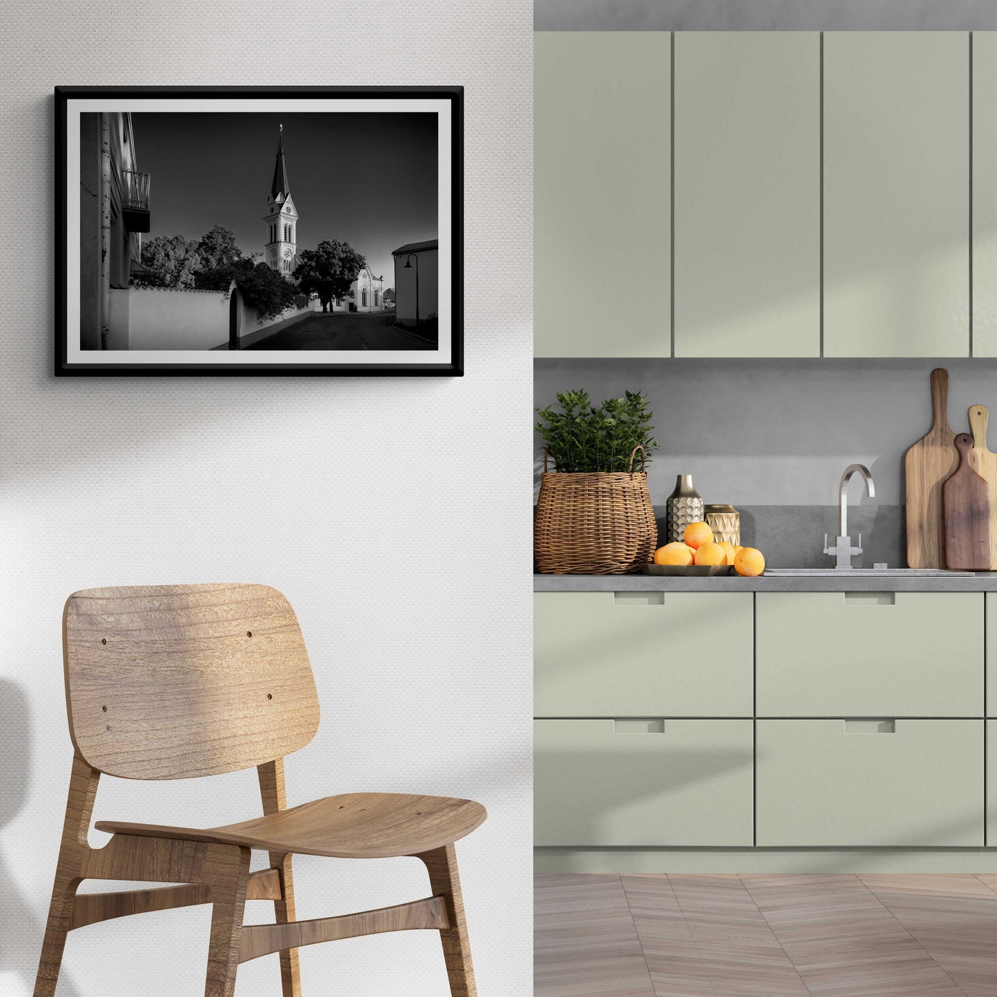 A framed print of the black and white image of an Autrian Church and Steeple in a room setting
