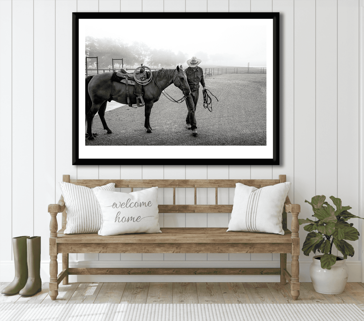 Morning Ride – Saddling Up in the Fog, Black and White Ranch Print by Michael Hart displayed in a farmhouse-style entryway with bench and pillows. Limited edition Texas ranch wall art featuring cowboy and horse in misty morning light.