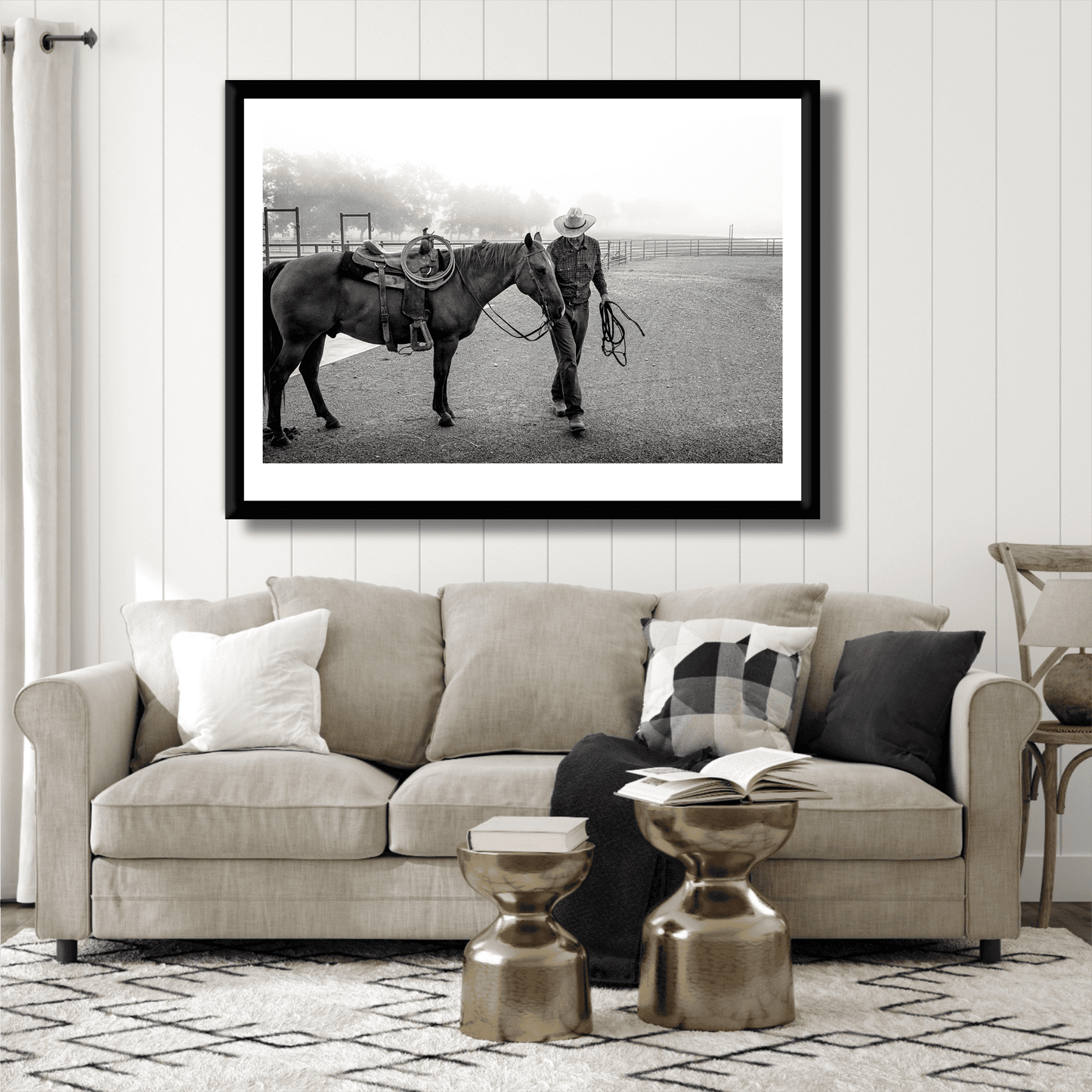 Morning Ride – Saddling Up in the Fog, Black and White Ranch Print by Michael Hart displayed above a beige sofa in a modern living room. Limited edition Texas ranch wall art featuring a cowboy and horse in morning fog.