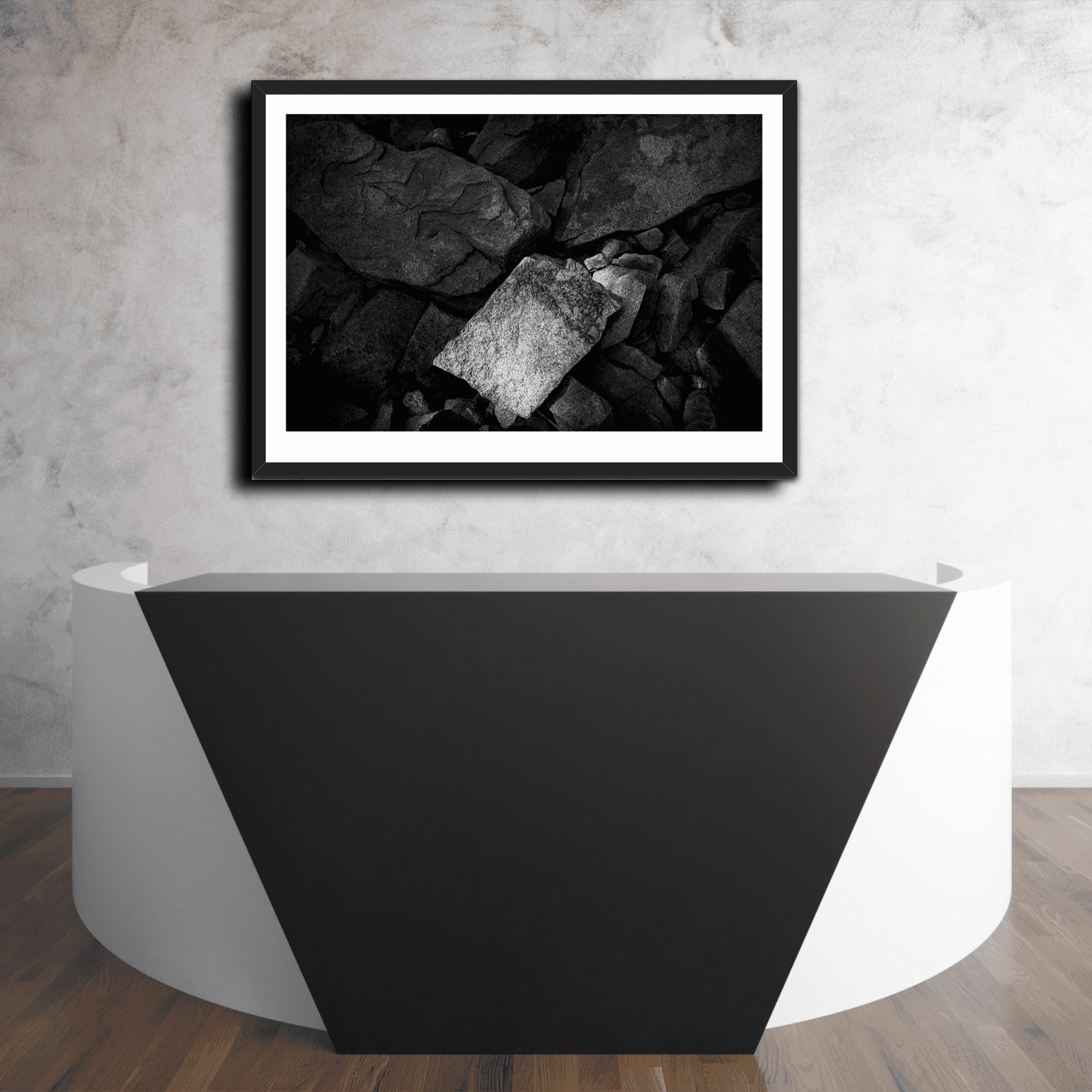 'Front and Center' monochrome rock formation artwork displayed above a geometric reception desk in a contemporary interior space.