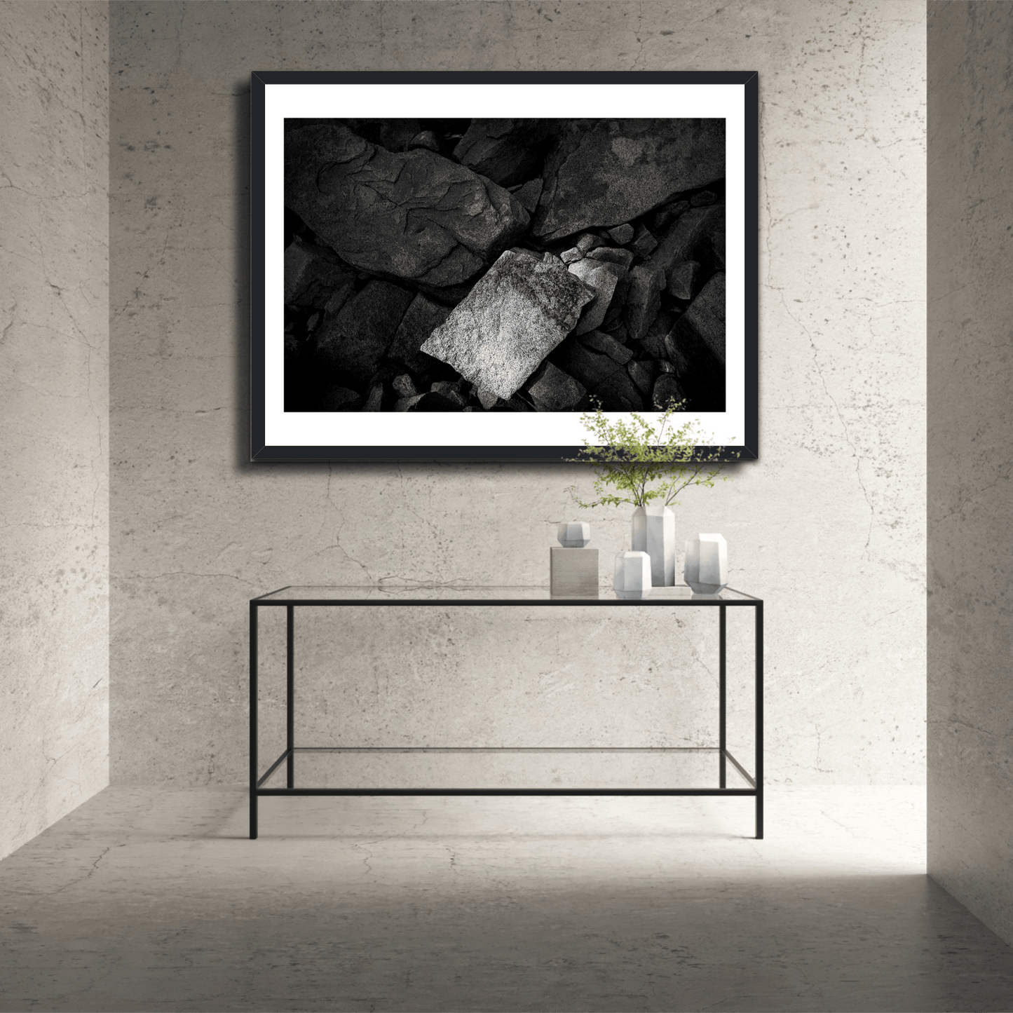 Framed black and white abstract rock formation photo titled 'Front and Center' displayed in a minimalist stone hallway with modern decor.