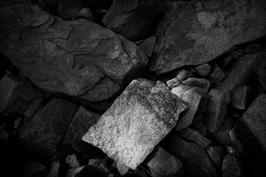 Abstract black and white photograph of angular rock formations along the Maine coast, highlighting texture, geometry, and contrast.