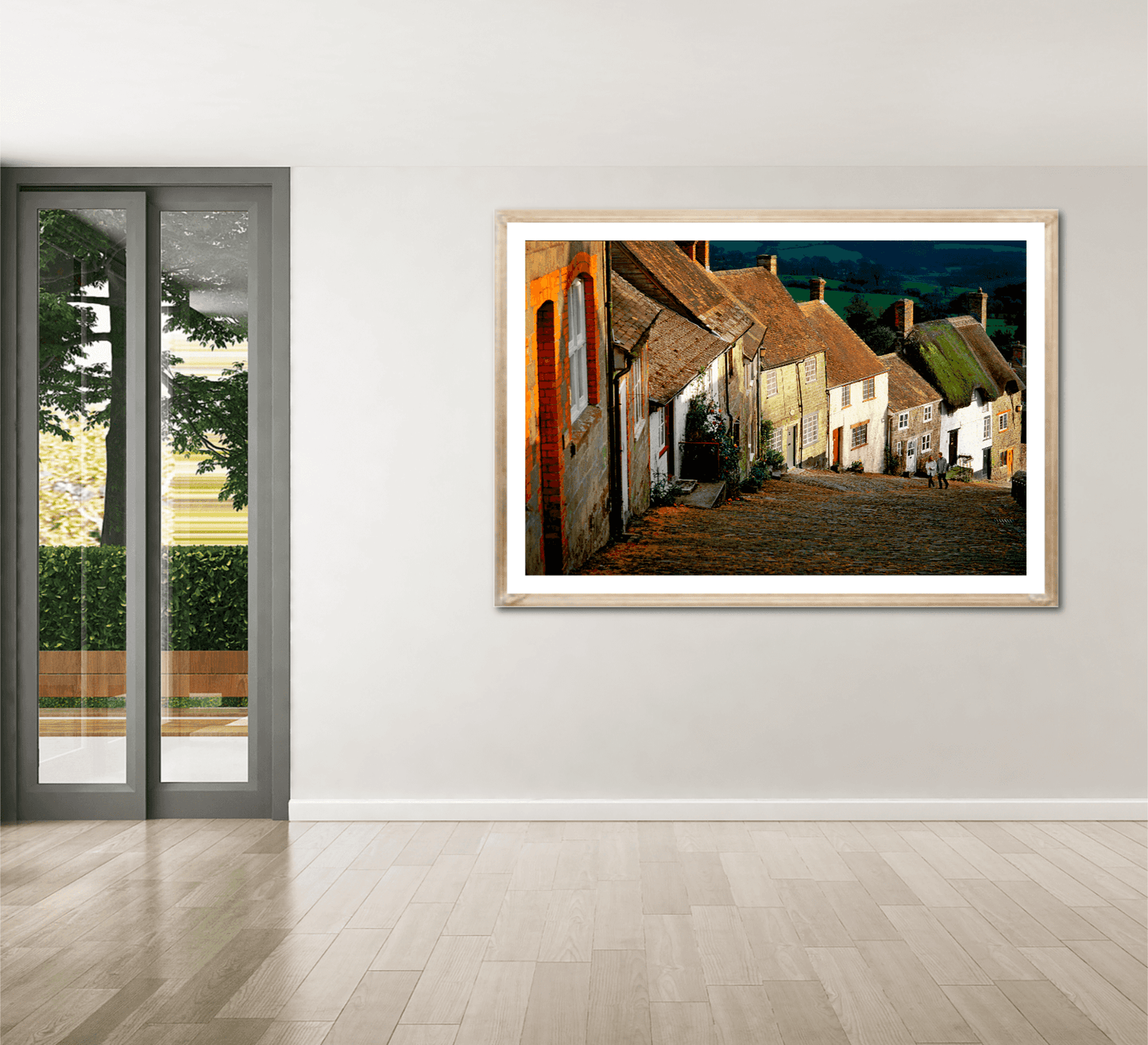 Gold Hill, Shaftesbury – A Fairy Tale Scene in Dorset large framed print showcased in a modern room with wooden flooring and glass doors.