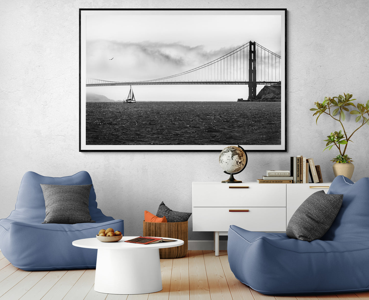 Framed black and white photo of sailboat transiting The Golden Gate Bridge in a modern sitting area with bean bag chairs