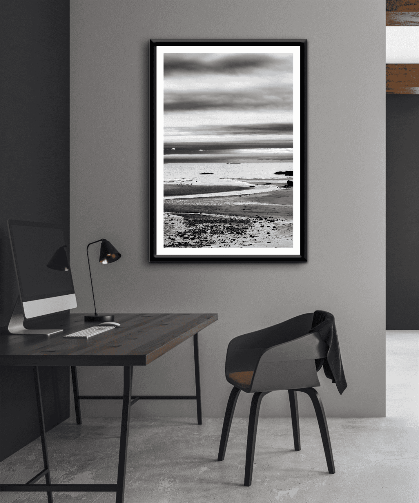 A print of a moody black and white image titled Grey Atlantic #1, moody coastal Maine image shown framed on the wall of a room setting