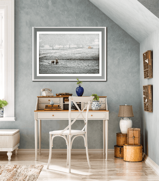 Framed Home for Christmas – The Cowboy and The Horse artwork displayed above a vintage writing desk, enhancing rustic holiday interior decor.