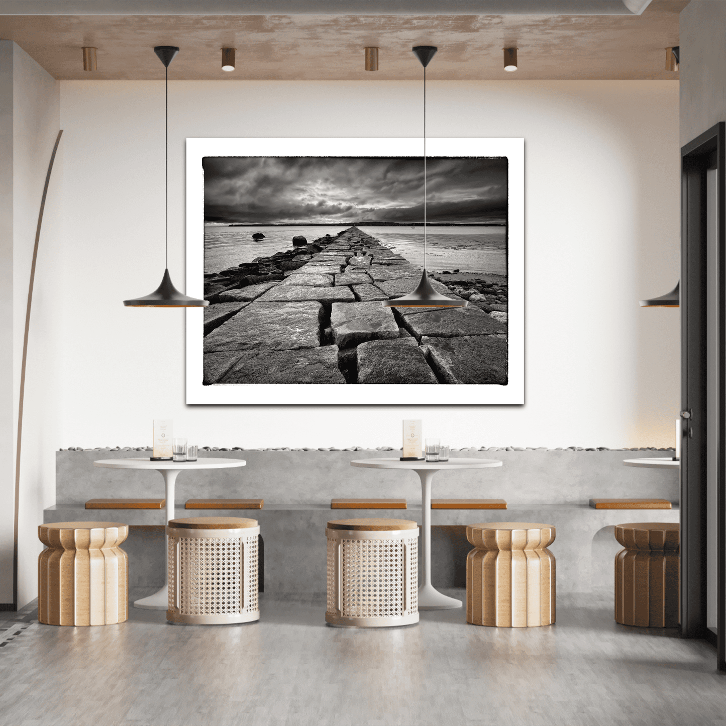 Breakwater, Rockland ME – Award-Winning Black & White iPhone Photo, Limited Edition Print displayed in modern cafe interior. Dramatic seascape art enhances minimalist decor.