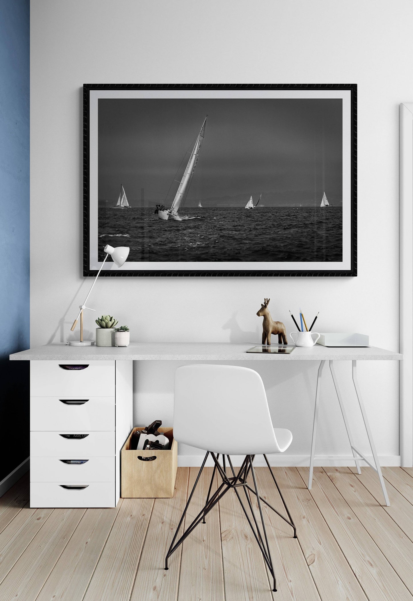 Framed black and white sailing photograph of a starboard tack on San Francisco Bay on the wall in a home office with white walls and furniture.
