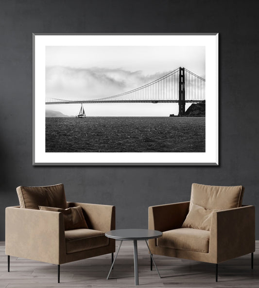 Black and white photo of Golden Gate Bridge with sailboat on the wall of a reception area.