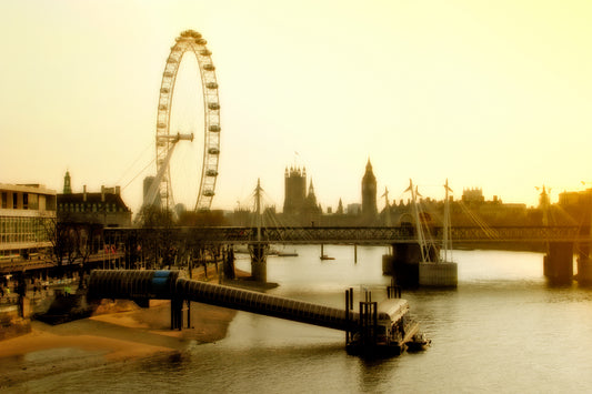 Fine art photograph of the London Eye and River Thames at golden hour, with bridges and Parliament forming a layered London skyline.