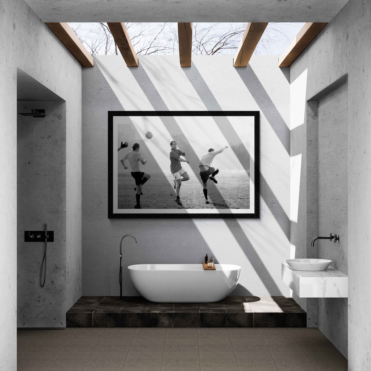 Black and white street photography of three men playing football in Hyde Park, London, with dramatic shadows and morning light, on the wall of a modern outdoor bathroom