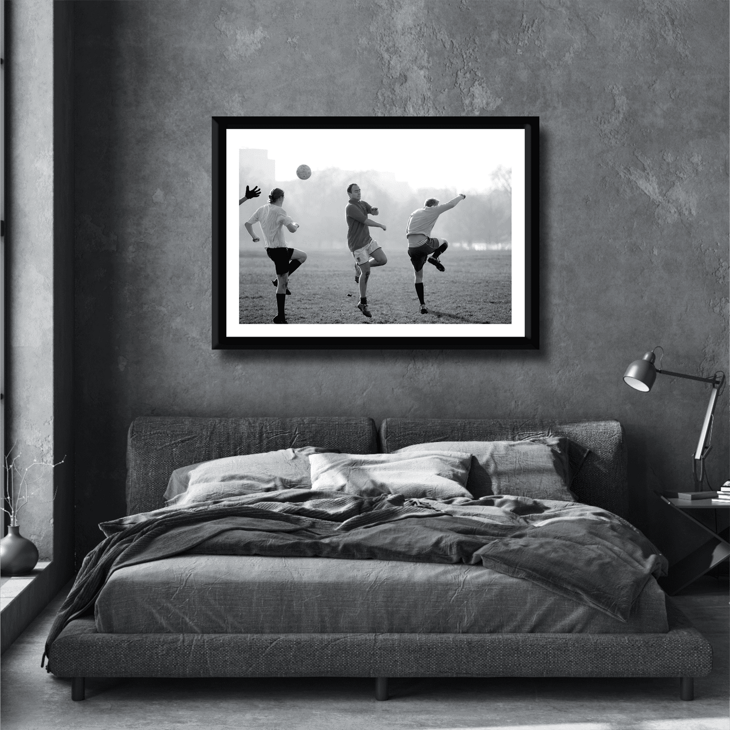 Black and white street photography print of three men playing football in Hyde Park, London on a stylish grey bedroom wall