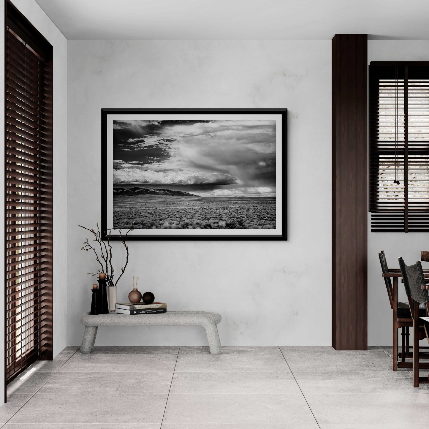 A black and white framed image of summer storm clouds over eastern Wyoming shown on the wall in a contemporary dining room setting 