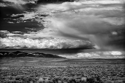 Black and white landscape photograph of storm clouds over eastern Wyoming with distant mountains and expansive sky.
