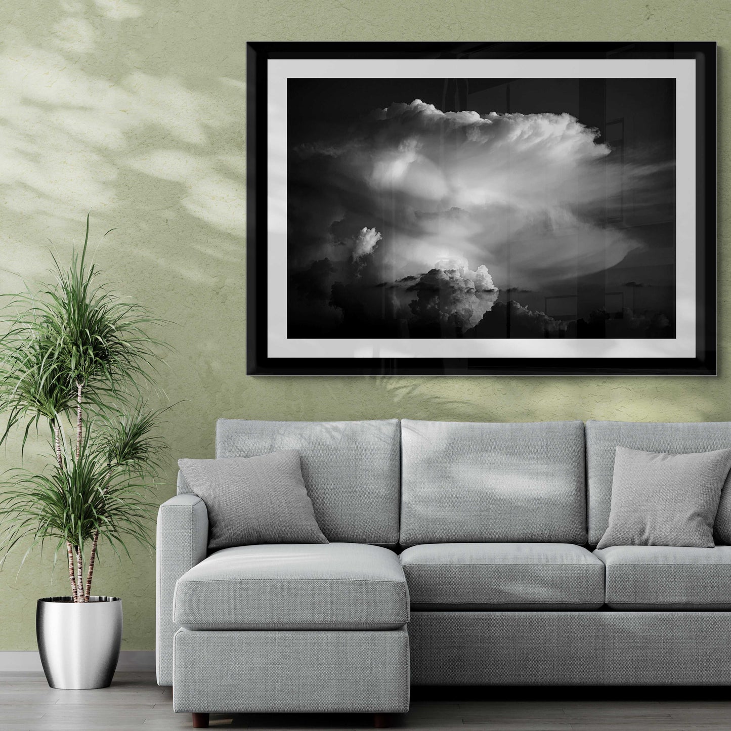 Thunderhead, Magnolia TX – Dynamic Texas Clouds in Black and White large format print above a gray sectional sofa in a stylish green-walled living space.